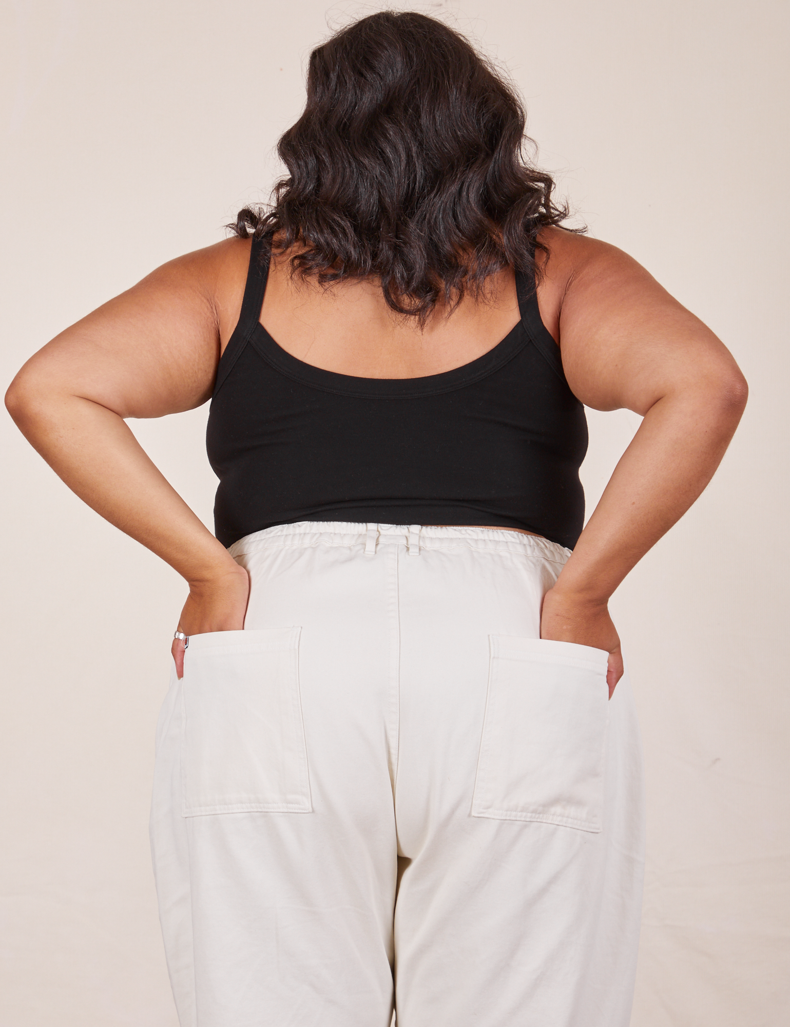 Back view of Cropped Cami in Basic Black and vintage tee off-white Western Pants worn by Alicia. She has both hands in the back pant pocket. 