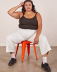 Alicia is sitting on an orange metal stool wearing Cropped Cami in Espresso Brown and vintage tee off-white Western Pants