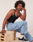 Jerrod is wearing Cropped Cami in Basic Black and light wash Carpenter Jeans