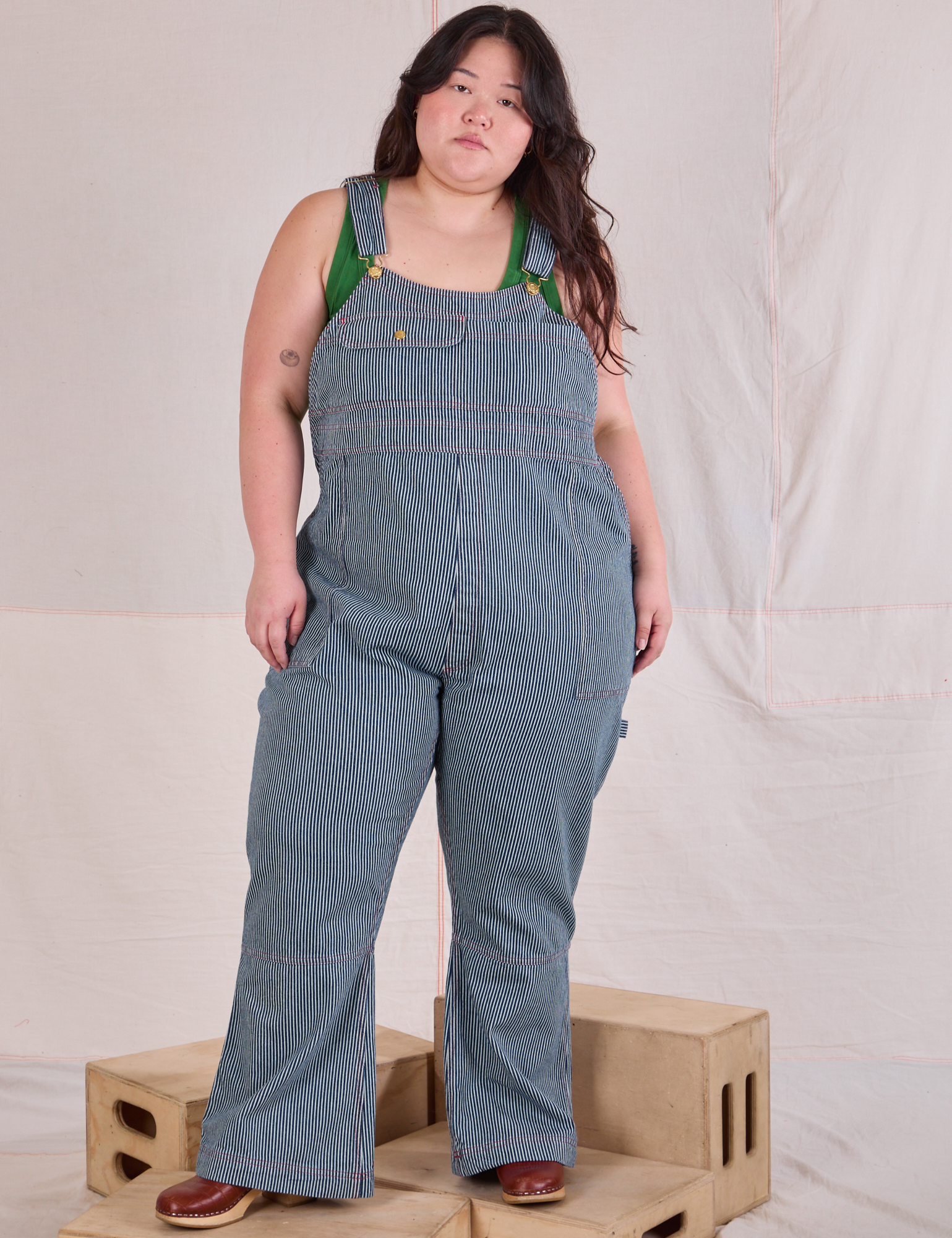 Ashley is 5'7" and wearing 1XL Carpenter Overalls in Railroad