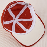 Dugout Corduroy Hat in Paprika flipped over. White satin under-bill.