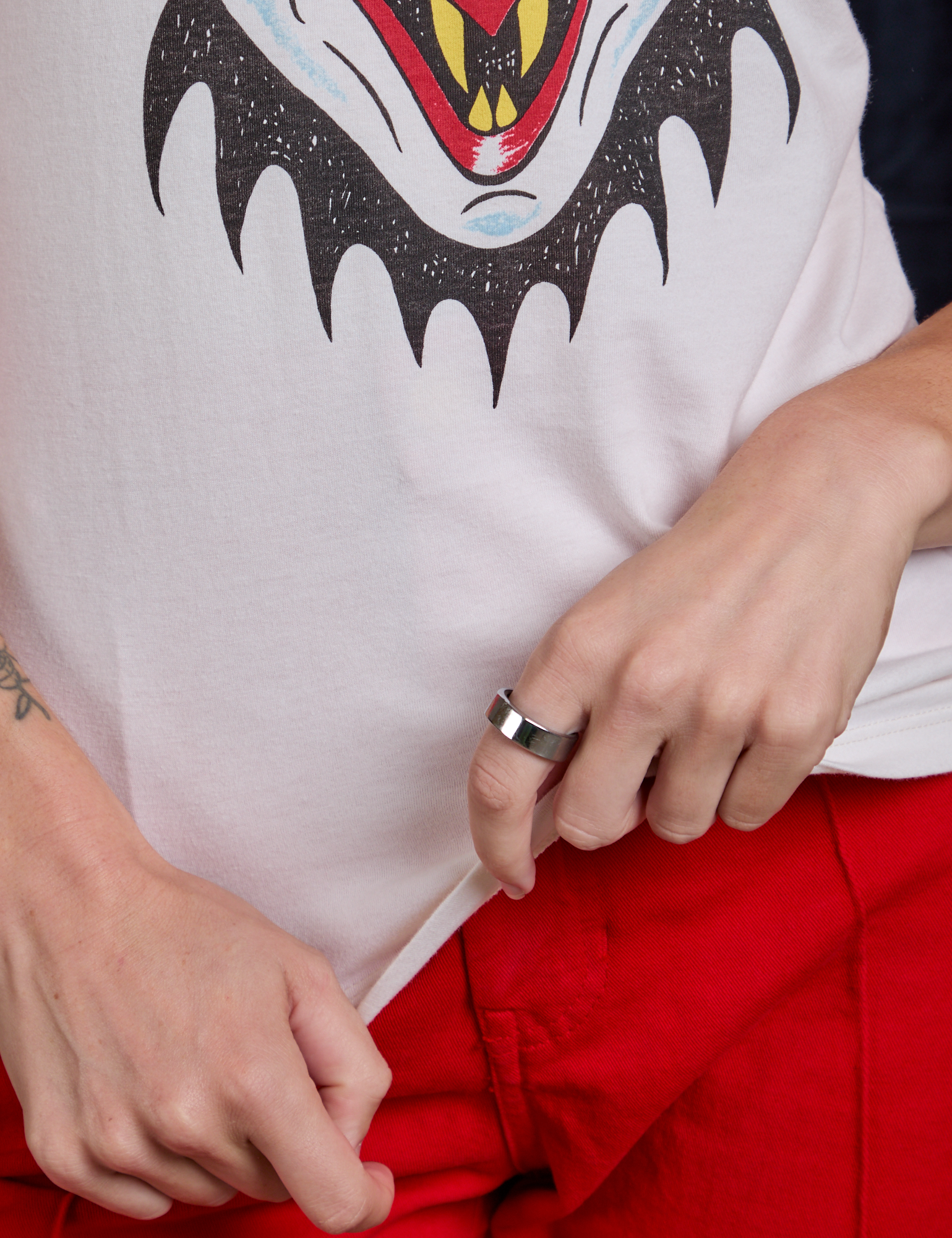 Alex is holding the bottom hem of Raglan Tee in Dracula