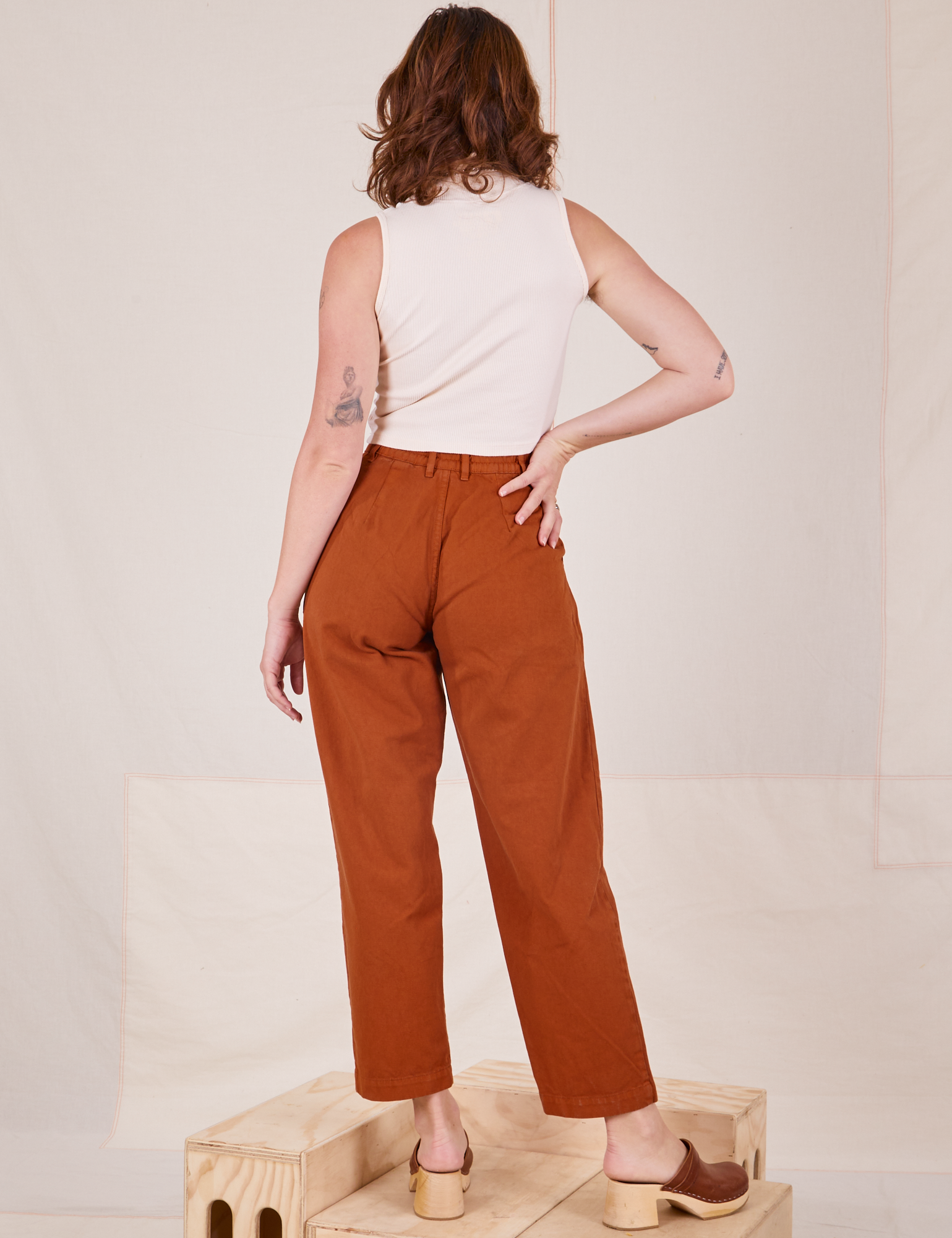 Back view of Heavyweight Trousers in Burnt Terracotta and Sleeveless Turtleneck in vintage tee off-white worn by Alex