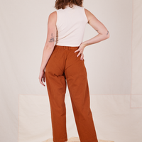 Back view of Heavyweight Trousers in Burnt Terracotta and vintage off-white Sleeveless Turtleneck worn by Alex