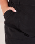 Heritage Short Sleeve Jumpsuit in Basic Black front pocket close up. Katie has her hand in the pocket.