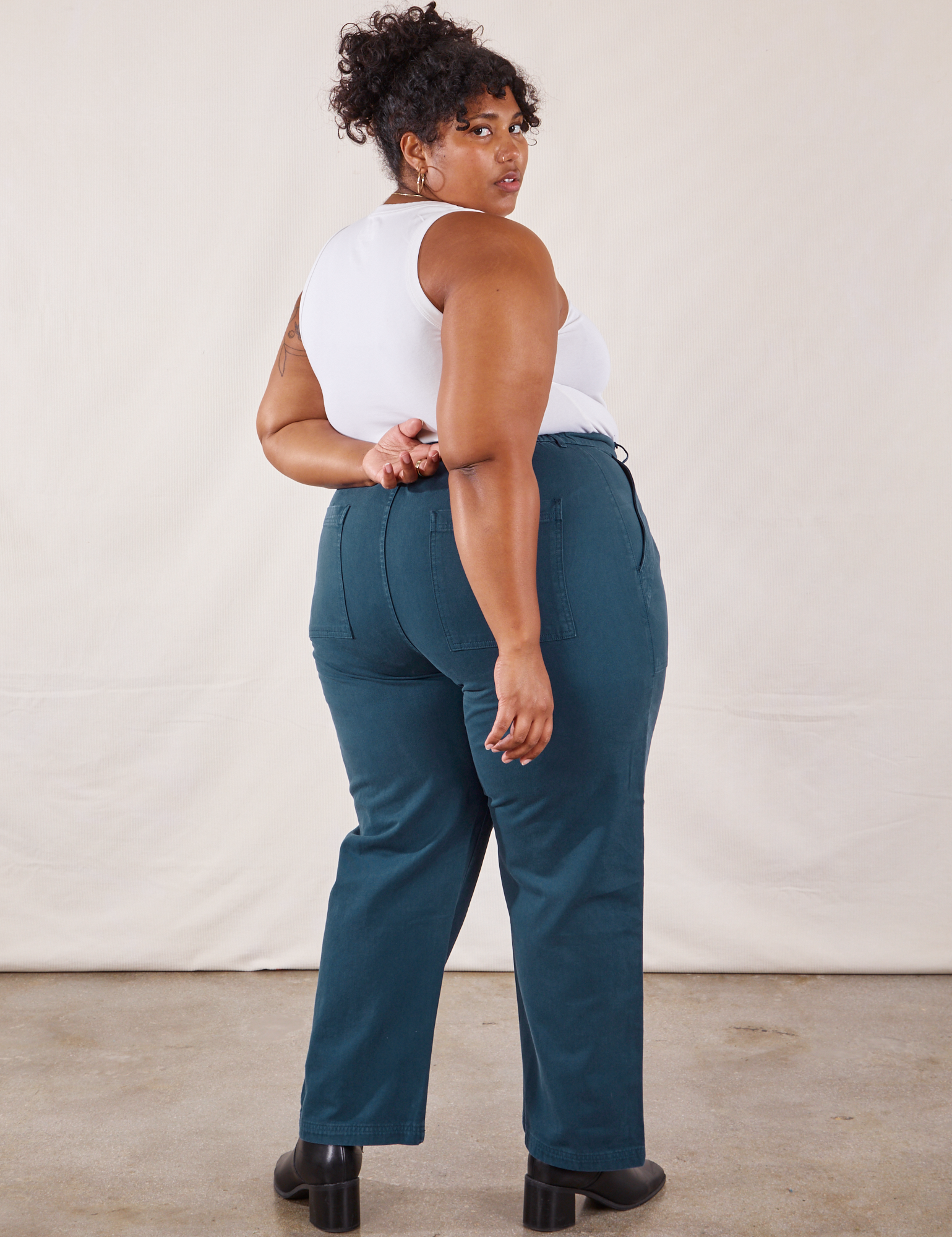 Angled back view of Work Pants in Lagoon and vintage tee off-white Tank Top