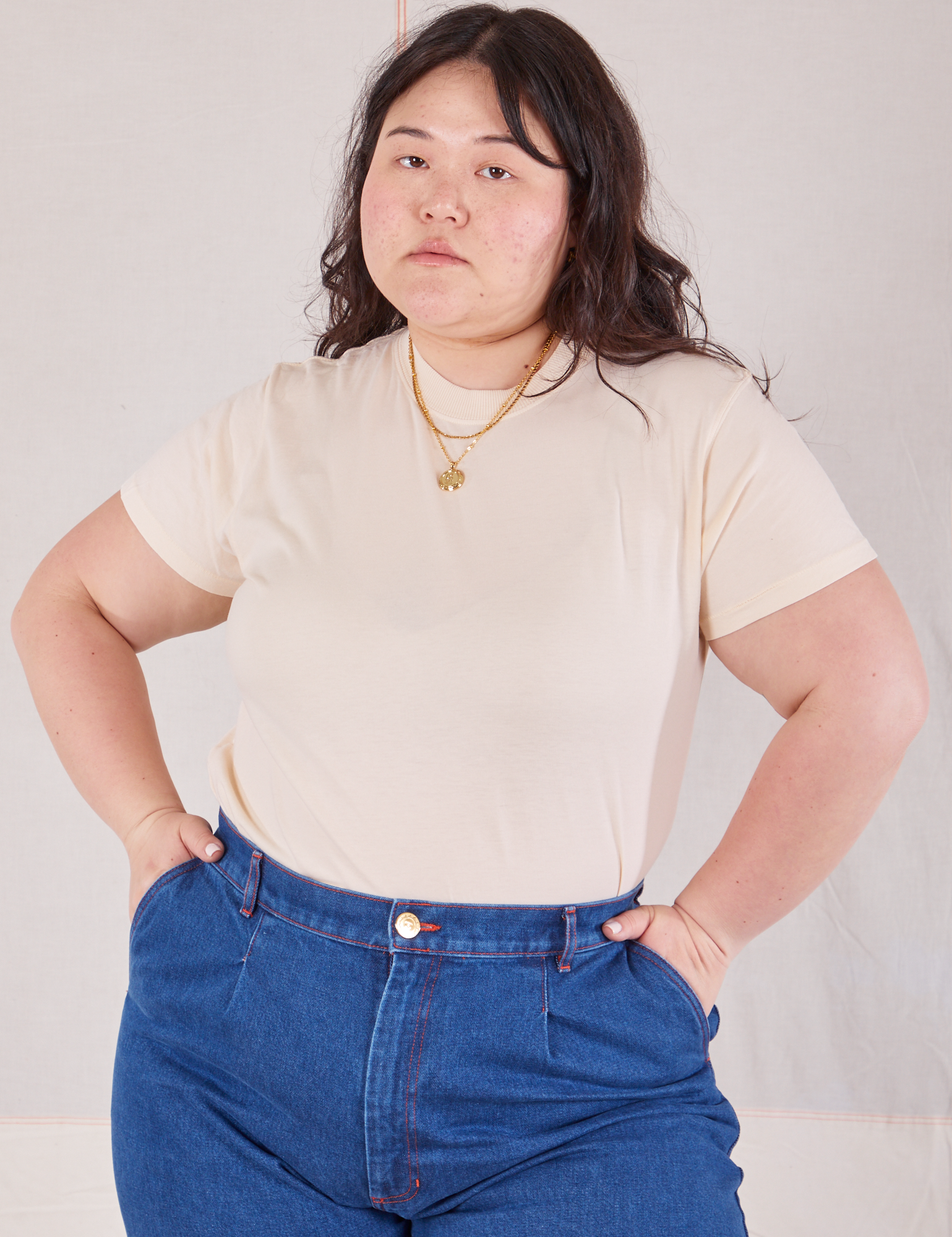 Ashley is 5'7" and wearing L Organic Vintage Tee in Vintage Tee Off-White tucked into dark wash Trouser Jeans