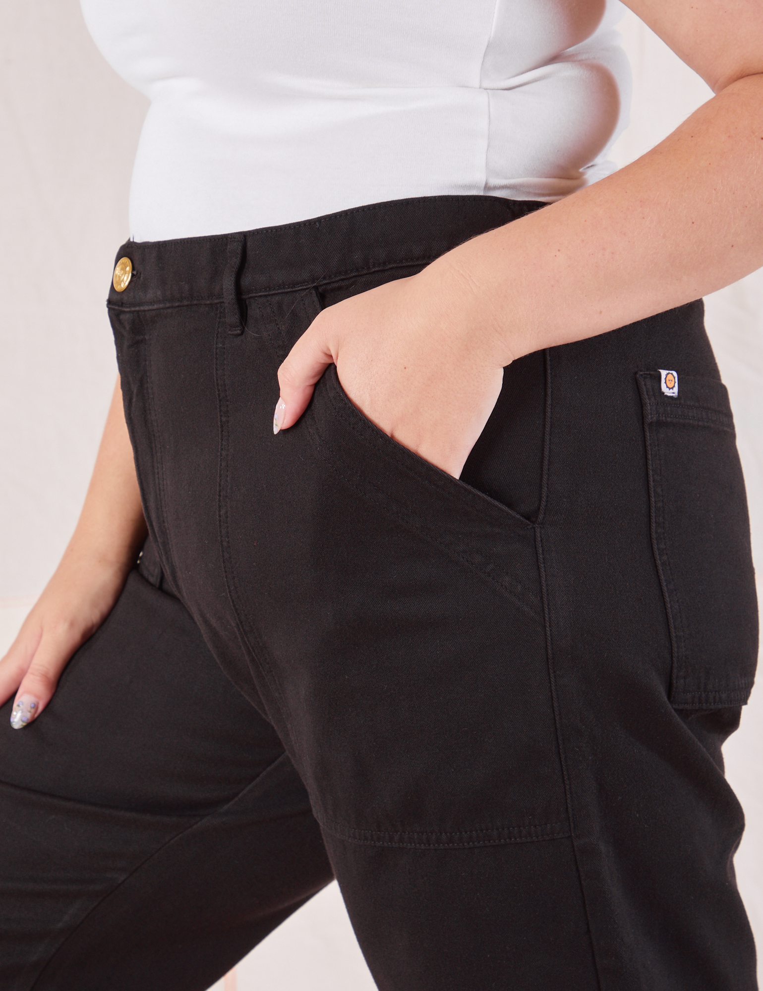 Organic Work Pants in Basic Black side close up. Ryan has her hand in the pocket.