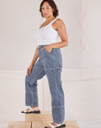 Side view of Carpenter Jeans in Indigo Railroad and vintage tee off-white Square Neck Tank