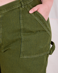 Close up of Ashley's hand in the front pocket of Railroad Carpenter Shorts in Summer Olive
