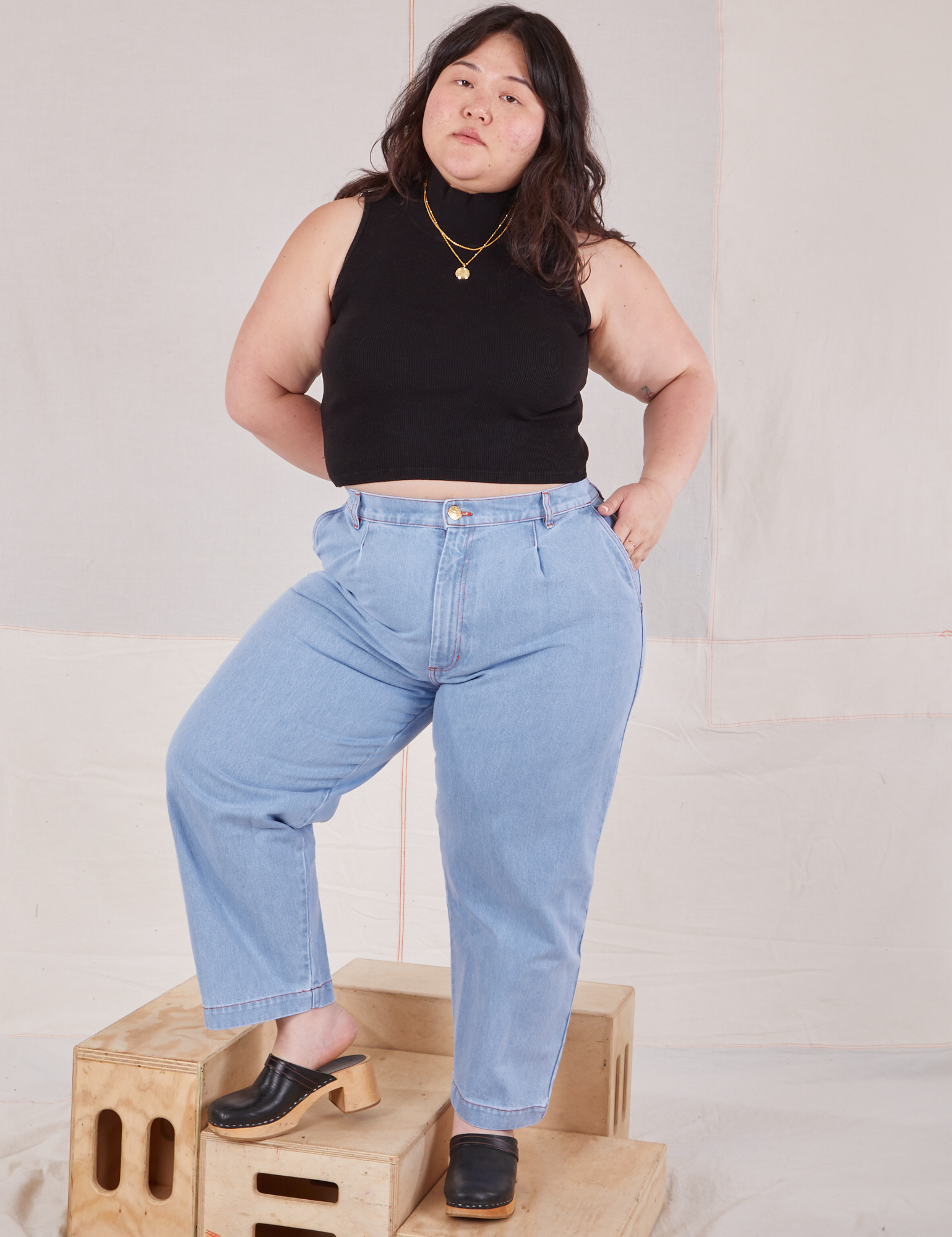 Ashley is wearing Sleeveless Essential Turtleneck in Basic Black and light wash denim Trouser Jeans