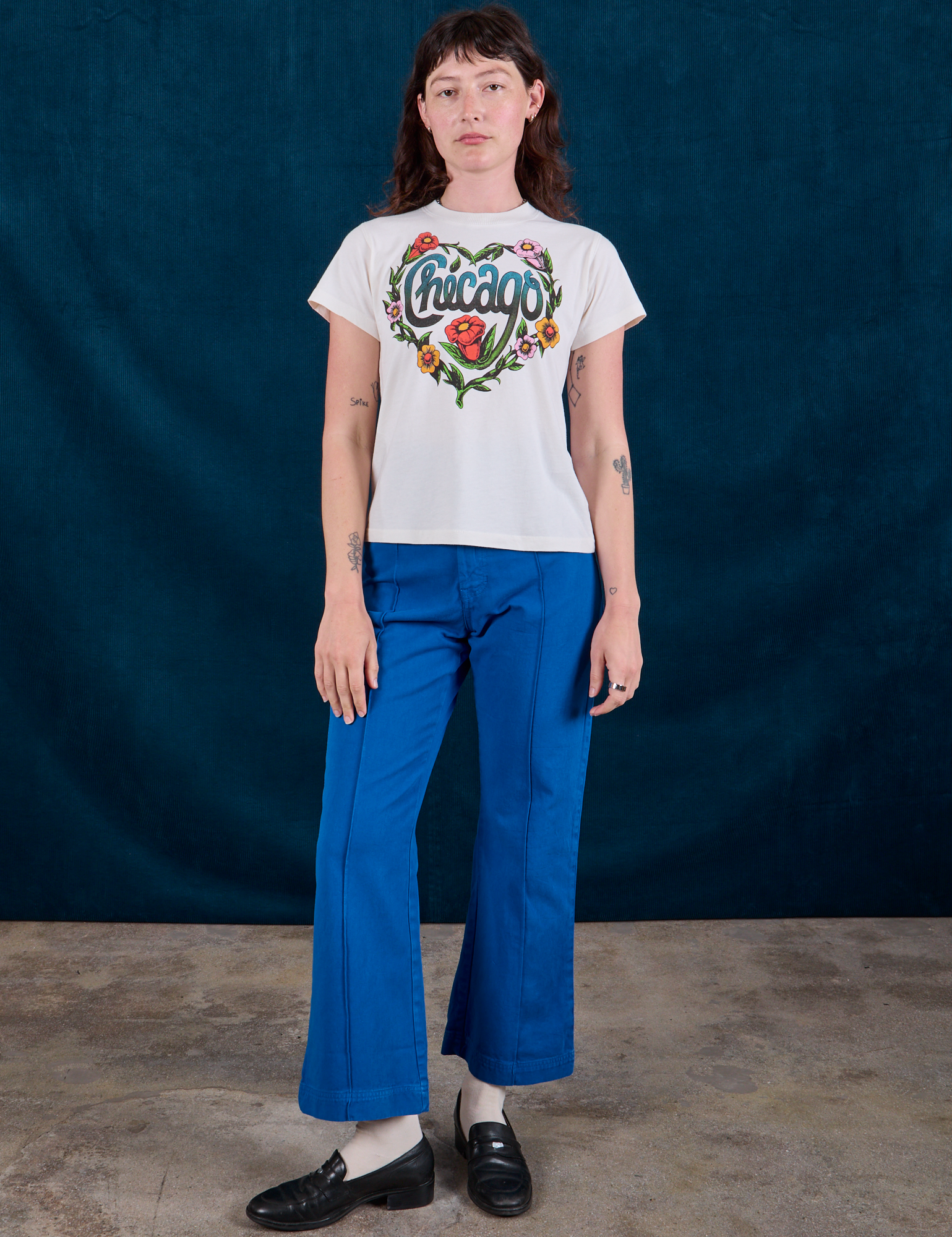 Alex is wearing Chicago Tourist Tee and royal blue Western Pants