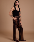 Angled front view of Black Stripe Work Pants in Fudgesicle Brown and black Cropped Tank on Anthony