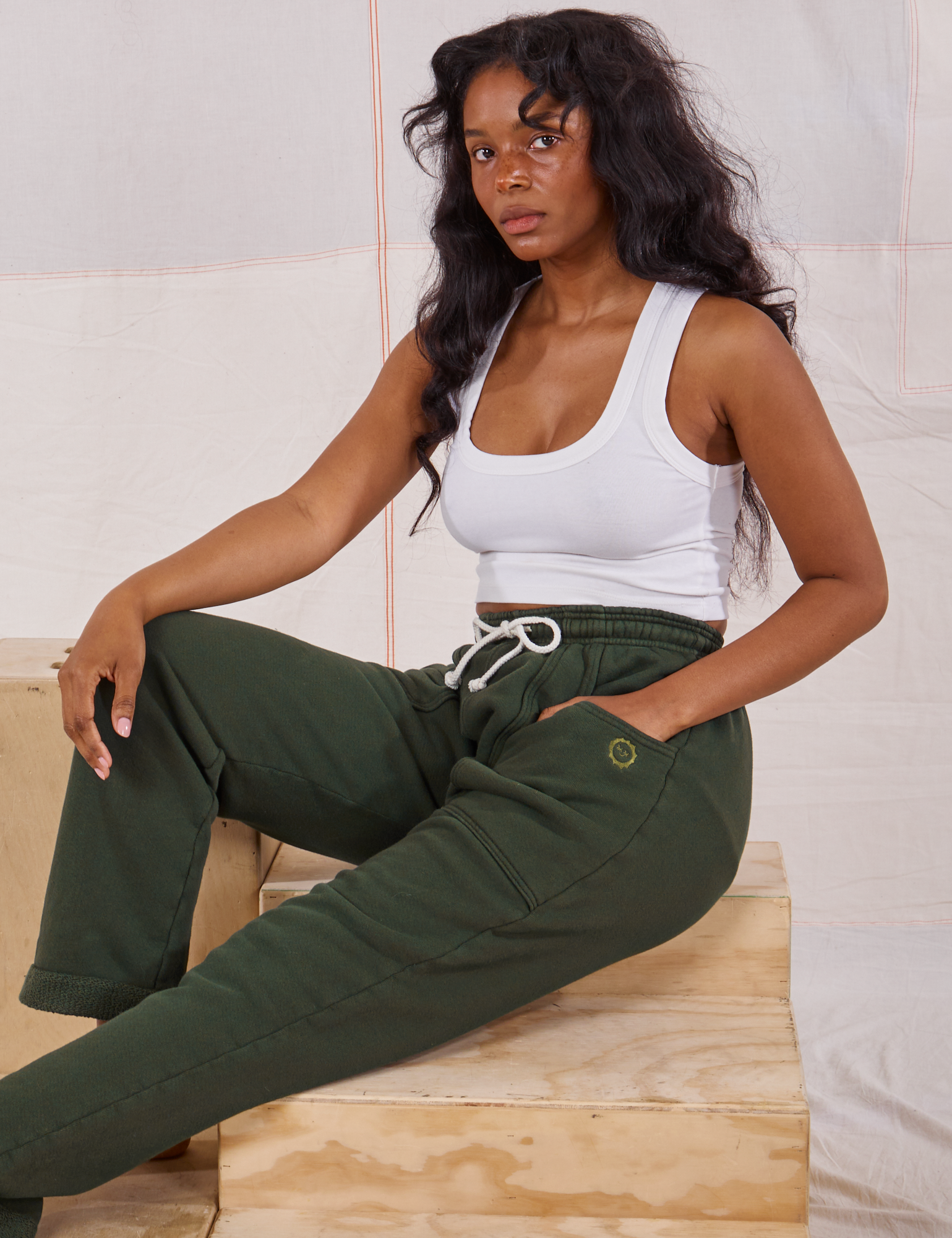Kandia is wearing Rolled Cuff Sweat Pants in Swamp Green and vintage off-white Cropped Tank