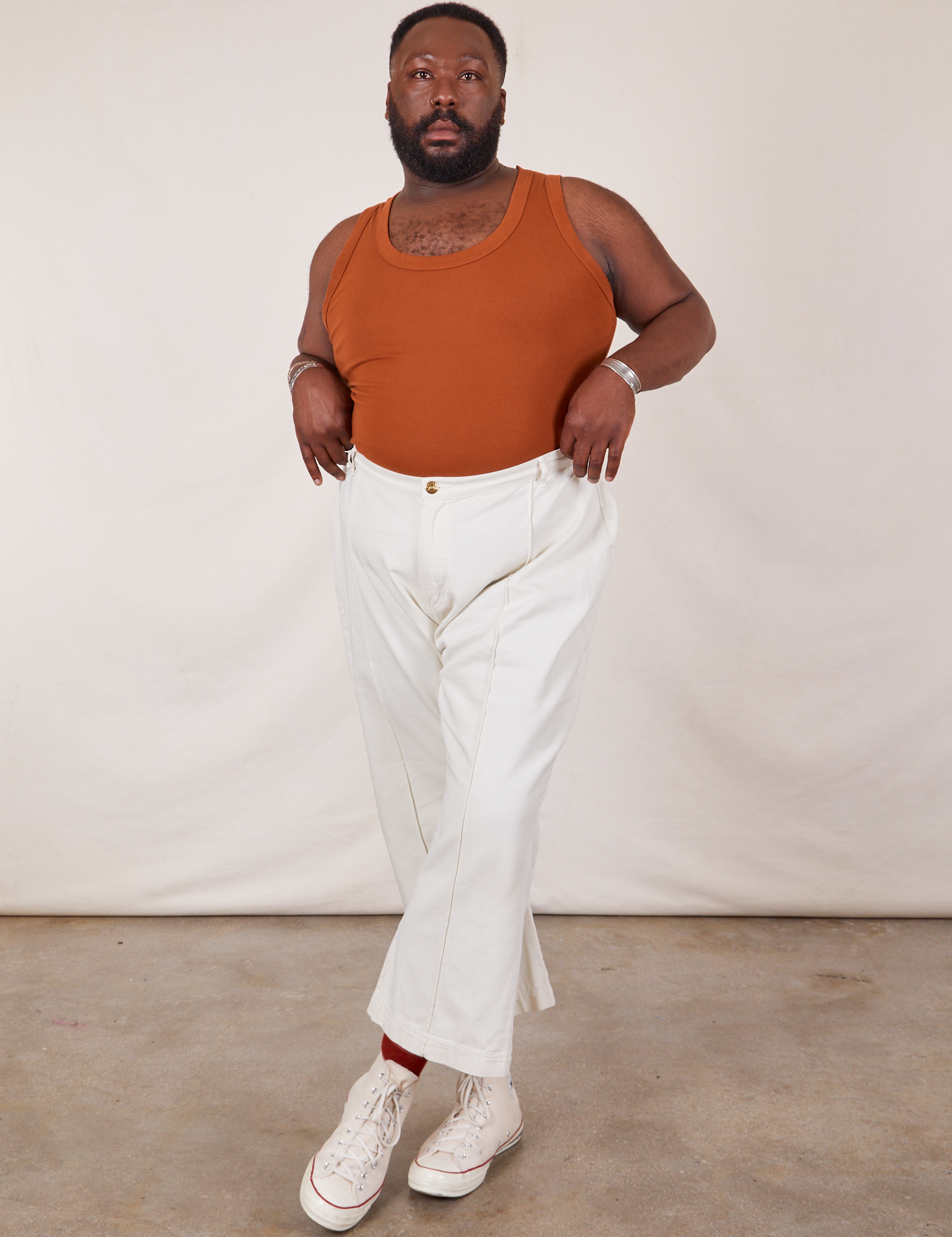 Elijah is wearing Tank Top in Burnt Terracotta tucked into vintage tee off-white Western Pants