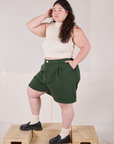 Angled front view of Trouser Shorts in Swamp Green and Sleeveless Turtleneck in Vintage Tee Off-White on Ashley