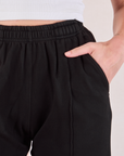 Close up of Alex's hand in the pocket of the Easy Western Pants in Basic Black