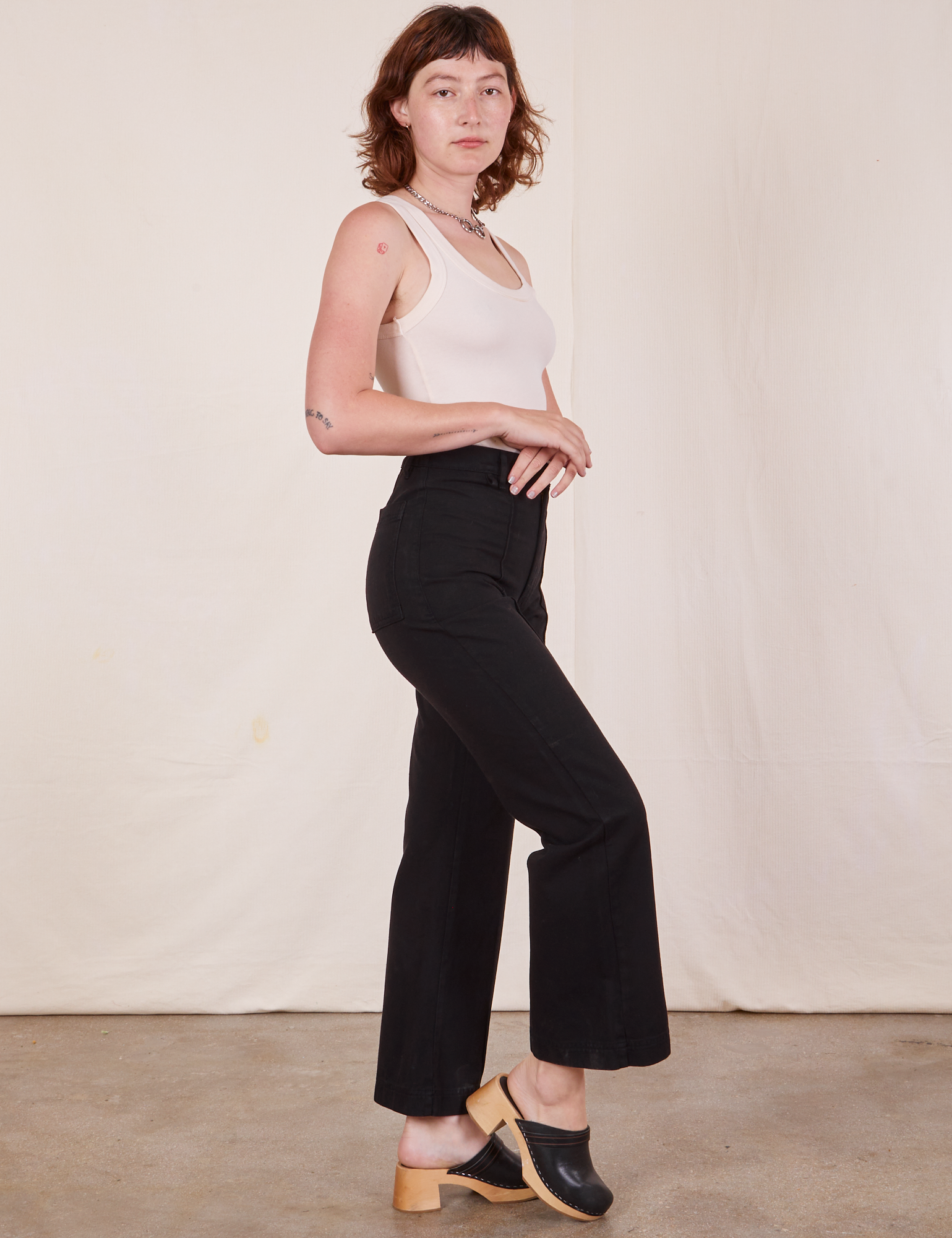 Side view of Western Pants in Basic Black and Tank Top in vintage tee off-white worn by Alex