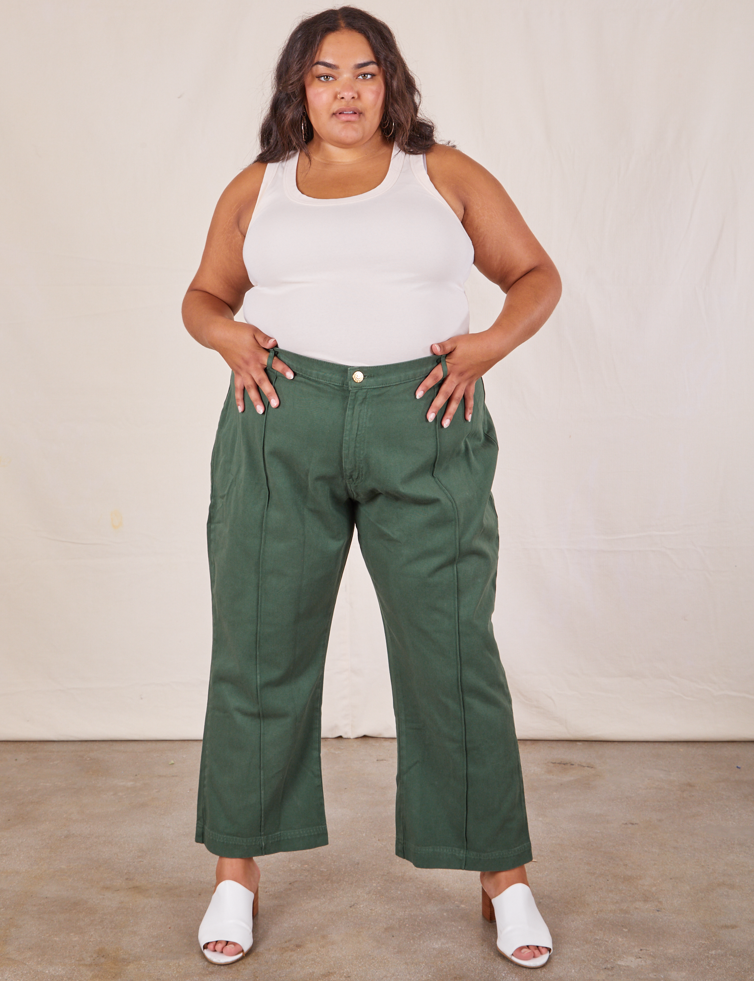 Alicia is 5&#39;9&quot; and wearing 2XL Western Pants in Dark Green Emerald paired with a vintage off-white Tank Top