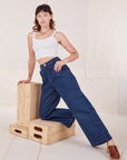 Alex is wearing Indigo Wide Leg Trousers in Dark Wash and vintage off-white Cami