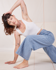 Alex is wearing Indigo Wide Leg Trousers in Light Wash and vintage off-white Cropped Tank Top