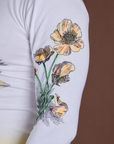 Close up of screen-printed flower on sleeve of Floral Long Sleeve Baby Tee in Yellow