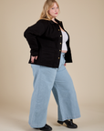 Side view of Work Jacket in Basic Black and light wash Indigo Wide Leg Trousers on Juliet