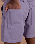 Close up of Isaac's hand in the back pocket of Classic Work Shorts in Faded Grape