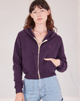Alex is wearing a zipped Cropped Zip Hoodie in Nebula Purple