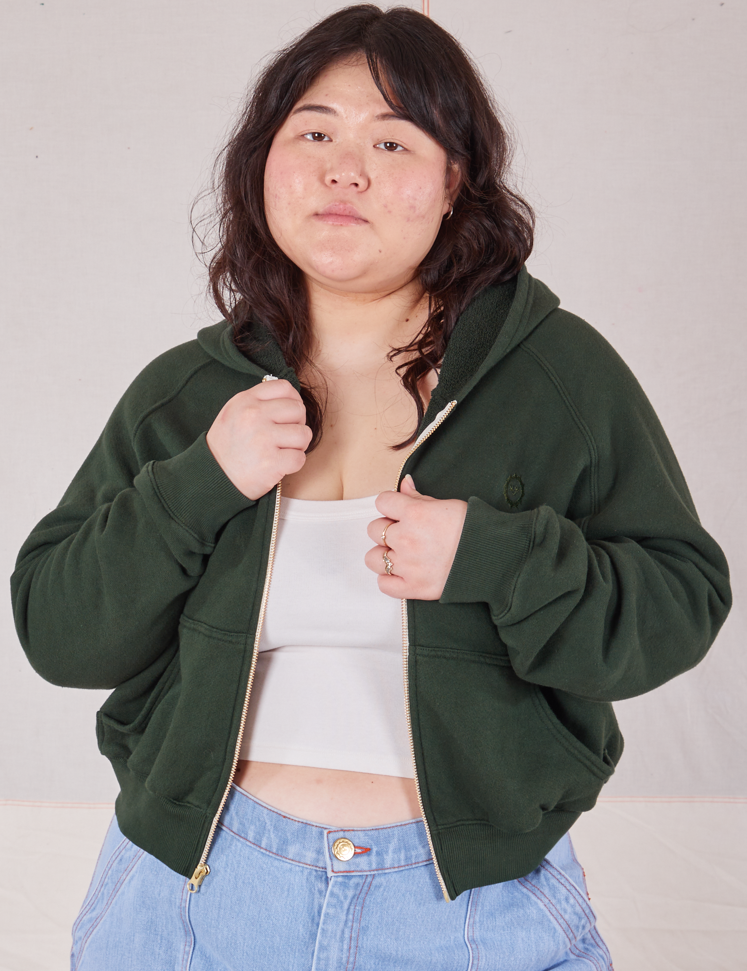 Ashley is wearing Cropped Zip Hoodie in Swamp Green with a vintage off-white Cropped Tank underneath