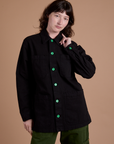 Alex is wearing a buttoned up Ripstop Field Coat in Basic Black