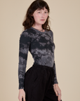 Angled front view of Long Sleeve Baby Tee in Black Magic Waters on Alex