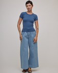 Alex is 5'8" and wearing P Baby Tee in French Blue paired with light wash denim wide leg trousers