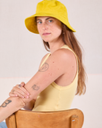 Scarlett is wearing Wide Brim Denim Bucket Hats in Golden Yellow