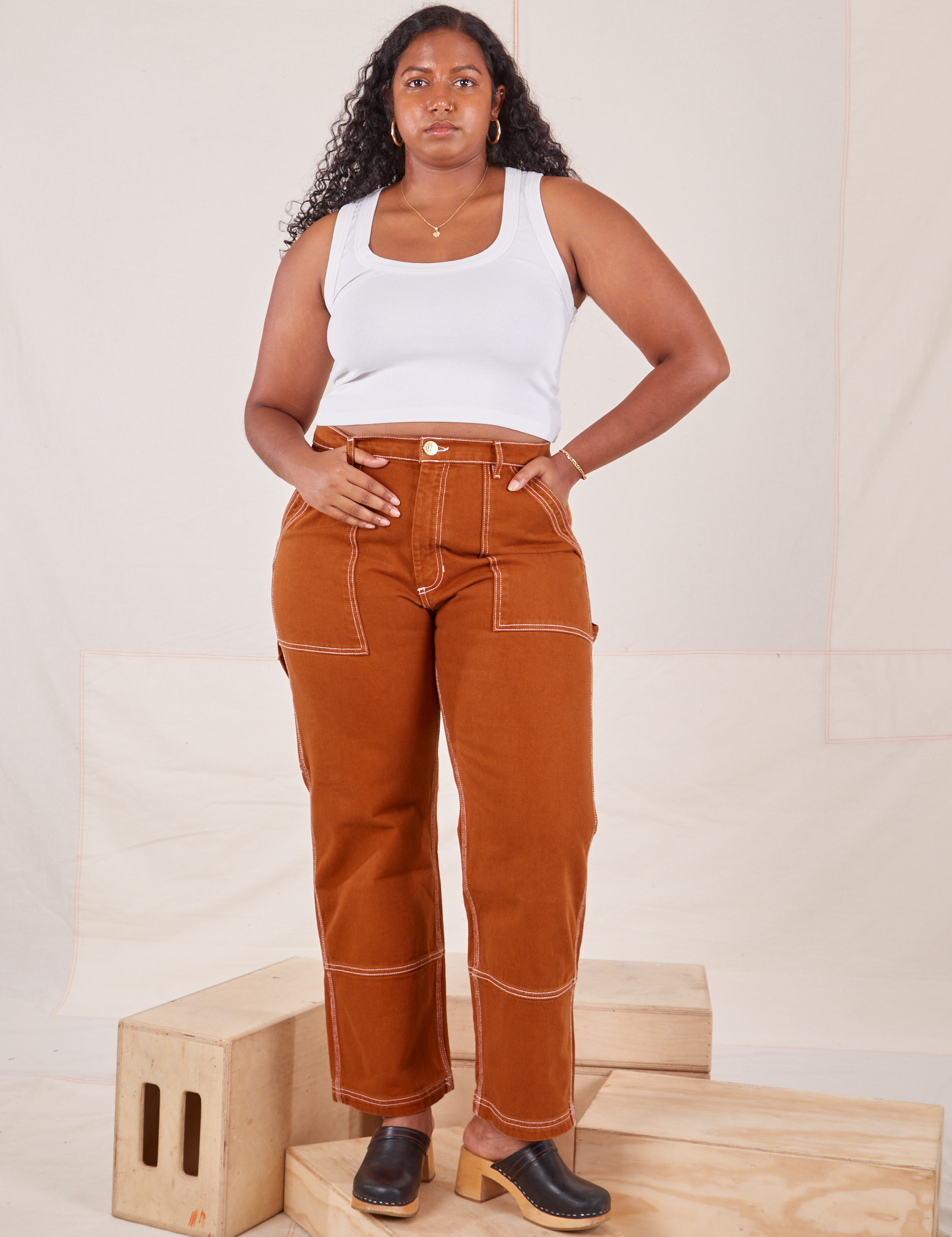 Meghna is 5&#39;8&quot; and wearing L Carpenter Jeans in Burnt Terracotta paired with Cropped Tank Top in vintage tee off-white 