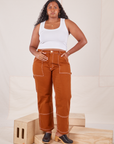 Meghna is 5'8" and wearing L Carpenter Jeans in Burnt Terracotta paired with Cropped Tank Top in vintage tee off-white 