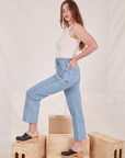 Side view of Carpenter Jeans in Light Wash and Tank Top in vintage tee off-white worn by Allison