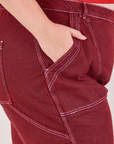 Bree has her hand in the pocket of the Railroad Carpenter Jeans in Mustang Red