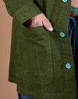 Close up of Sam's hand in the front pocket of Ripstop Field Coat in Evergreen