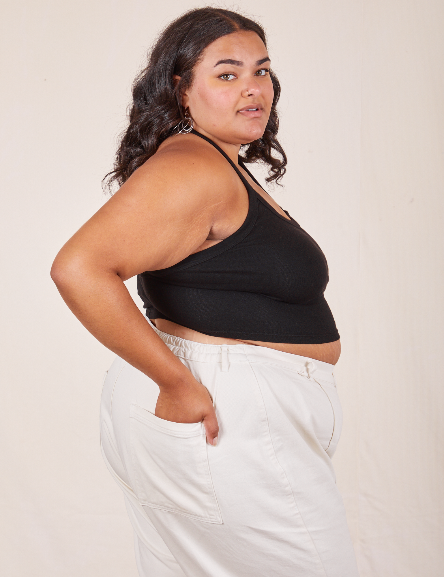 Side view of Halter Top in Basic Black and vintage off-white Western Pants worn by Alicia