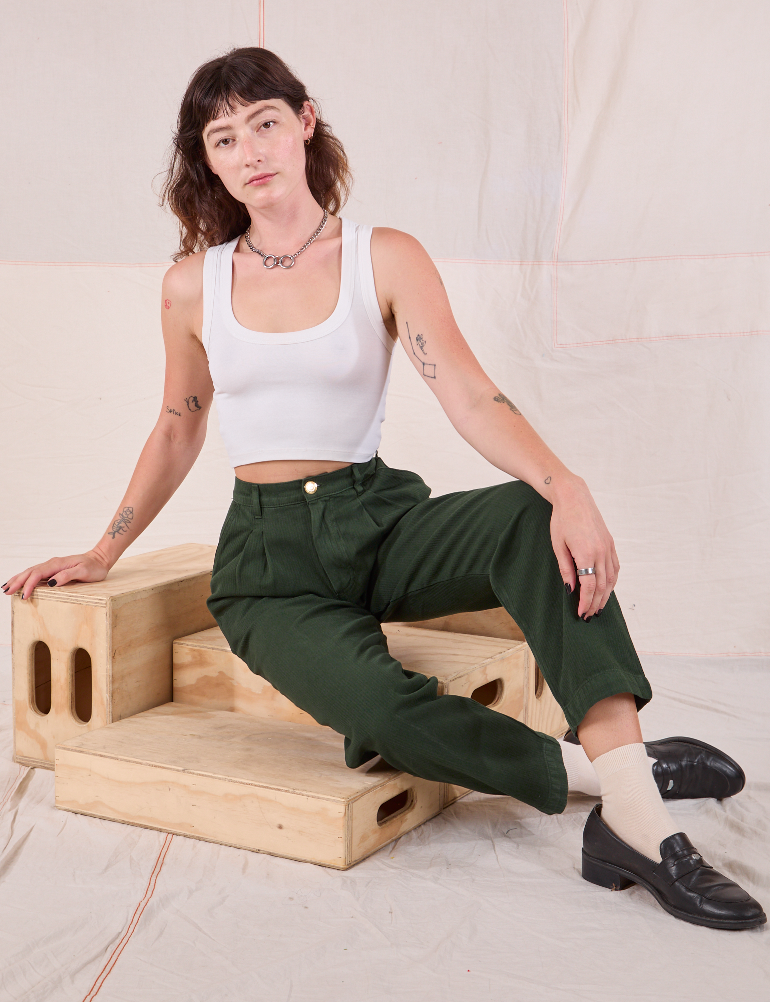 Alex is wearing Heritage Trousers in Swamp Green and Cropped Tank in vintage tee off-white