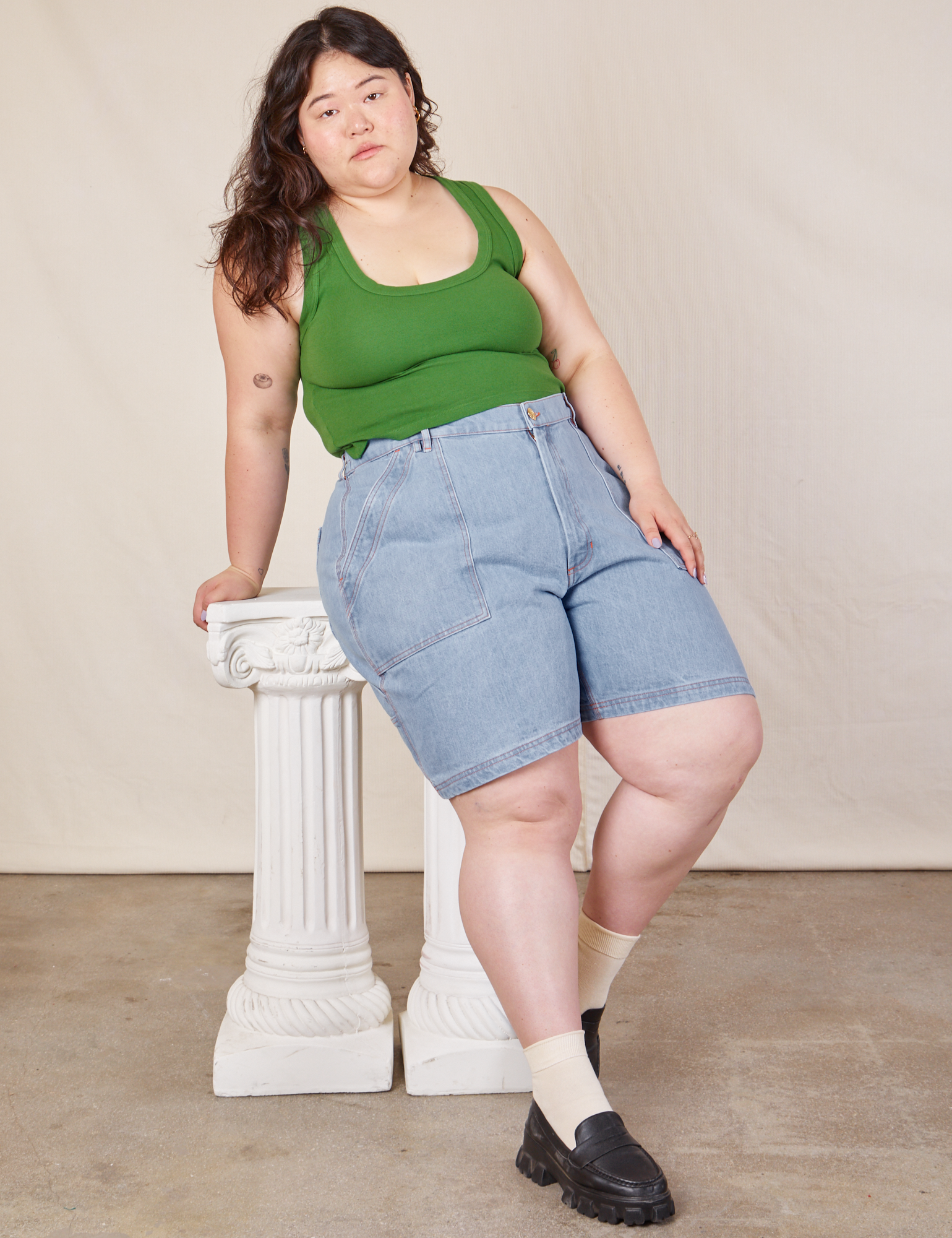 Ashley is wearing Carpenter Shorts in Light Wash and lawn green Cropped Tank