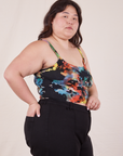 Side view of Cropped Cami in Rainbow Magic Waters and black Petite Western Pants worn by Ashley