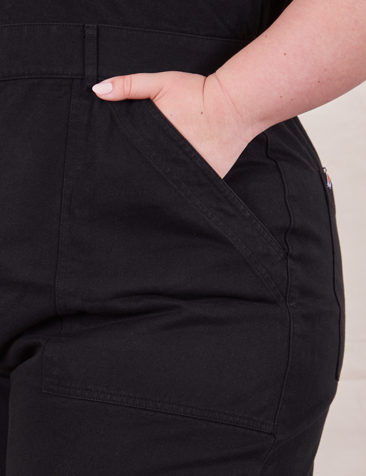 Front pocket close up of Petite Short Sleeve Jumpsuit in Basic Black worn by Ashley