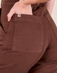 Short Sleeve Jumpsuit in Fudgesicle Brown back pocket close up. Alex has her hand in the pocket.