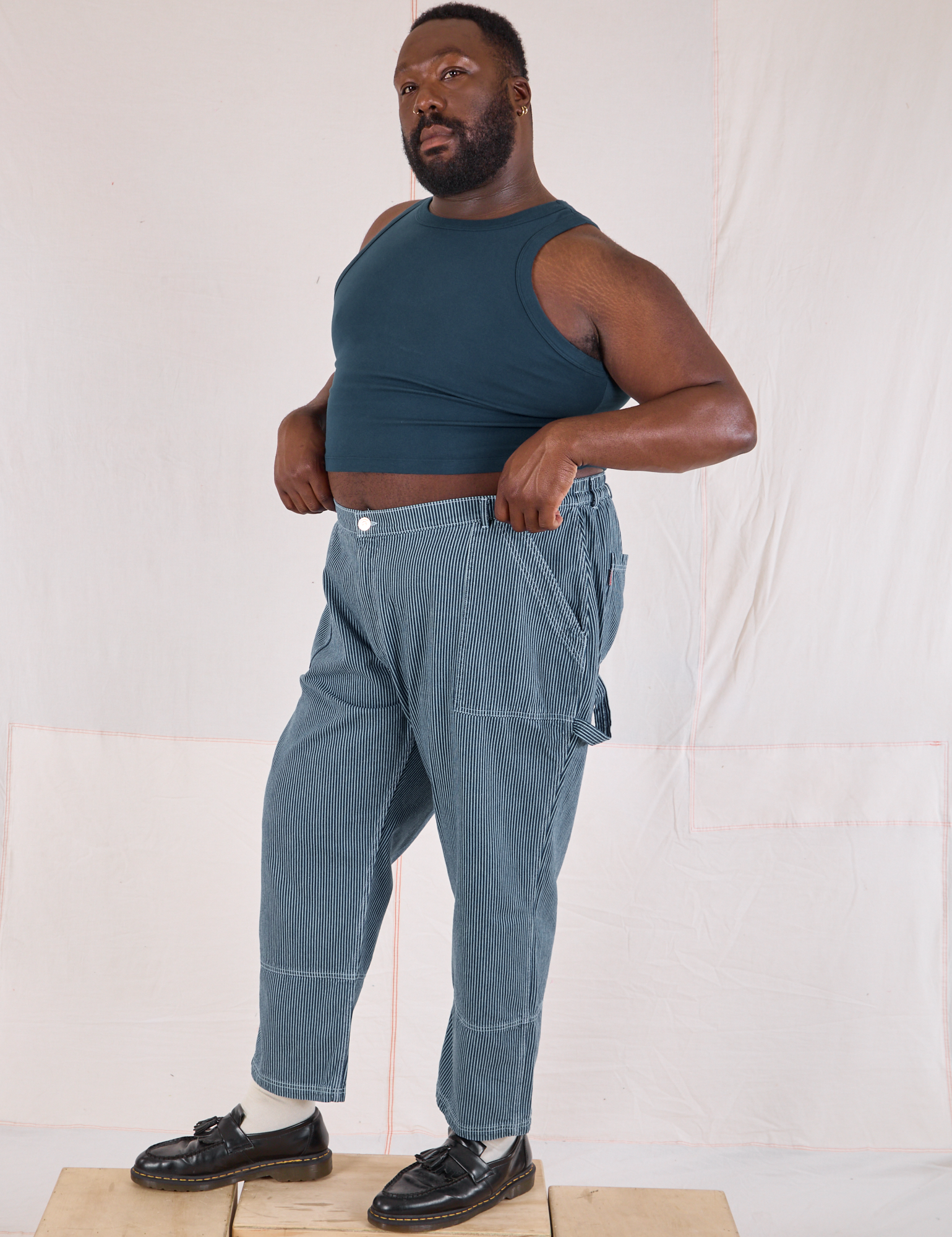 Angled front view of Railroad Carpenter Jeans in Baby Blue and marine blue Muscle Tee on Elijah