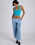 Kira is wearing Cropped Tank Top in Hawaiian Blue and light wash Denim Drop Pocket Pants