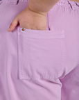 Close up of Juliet's hand in the back pocket of Longline Work Shorts in Lilac Purple