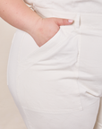 Front pocket close up of Short Sleeve Jumpsuit in Vintage Tee Off-White. Ashley has her hand in the pocket.