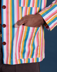 Close up of Isaac's hand in the front pocket of Stripe Work Jacket in Rainbow Stripe